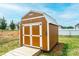 Charming backyard shed with a white-trimmed door and a wooden walkway leading to the entrance at 201 S 5Th Ave, Maiden, NC 28650