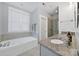 Bright bathroom with a soaking tub, glass shower, and granite countertops at 228 Coneflower Pl, Fort Mill, SC 29708
