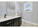 Stylish bathroom with dark cabinets, a white countertop, and a large framed mirror at 228 Coneflower Pl, Fort Mill, SC 29708