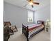 Bright bedroom features a ceiling fan, white carpet, rocking chair, and striped bedding at 228 Coneflower Pl, Fort Mill, SC 29708