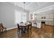 Dining area featuring hardwood floors, coffered ceiling, chandelier, and kitchen pass-through at 228 Coneflower Pl, Fort Mill, SC 29708