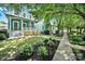 A beautiful blue home featuring manicured landscaping with a sidewalk and a tree-lined street at 228 Coneflower Pl, Fort Mill, SC 29708