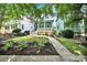 Charming two-story home with a covered front porch and landscaped garden on a sunny day at 228 Coneflower Pl, Fort Mill, SC 29708