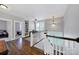 Bright hallway with hardwood floors leads to an office and bedroom with staircase views at 228 Coneflower Pl, Fort Mill, SC 29708