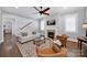 Cozy living room with a fireplace, hardwood floors, and comfortable seating with a ceiling fan at 228 Coneflower Pl, Fort Mill, SC 29708