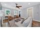 Bright living room with a fireplace, hardwood floors, and comfortable seating arrangement with a ceiling fan at 228 Coneflower Pl, Fort Mill, SC 29708