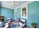 A charming turquoise porch features comfortable seating, a ceiling fan, and a stylish outdoor rug at 228 Coneflower Pl, Fort Mill, SC 29708