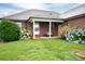 A brick home's inviting back porch with flower beds and a grassy yard at 2817 Long Cir # 1, Iron Station, NC 28080