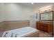 Bathroom featuring a white bathtub, a wood vanity with granite countertops, and a window at 2817 Long Cir # 1, Iron Station, NC 28080