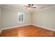 Comfortable bedroom showcasing gleaming hardwood floors, a ceiling fan, and natural light from the window at 2817 Long Cir # 1, Iron Station, NC 28080