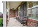 Comfortable front porch showcases a black wrought iron bench and brick facade at 2817 Long Cir # 1, Iron Station, NC 28080