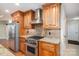 A kitchen featuring wood cabinets, granite countertops, stainless steel appliances, and a stainless steel vent hood at 2817 Long Cir # 1, Iron Station, NC 28080