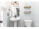 Cozy half bathroom complete with a pedestal sink and new light fixture at 2945 Duvalla Ave, Charlotte, NC 28209