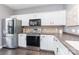 Bright kitchen featuring stainless steel appliances, white cabinets, and solid surface countertops at 2945 Duvalla Ave, Charlotte, NC 28209