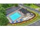 Aerial view of the community pool with chairs, umbrellas and adjacent to a parking lot at 3237 Yarmouth Ln, Gastonia, NC 28056