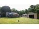 Large backyard featuring a storage building, a wooden deck, and mature shade trees at 332 Daybrook Dr, Landis, NC 28088