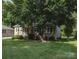 Exterior view of a well-kept home with mature trees, a welcoming porch, and green shutters at 332 Daybrook Dr, Landis, NC 28088