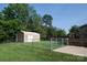 View of a backyard storage shed, surrounded by a chain link fence and mature trees at 332 Daybrook Dr, Landis, NC 28088