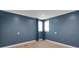 Blue bedroom with hardwood floors and two windows at 3333 Roberta Rd, Concord, NC 28027