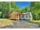 Back exterior view of home featuring a spacious backyard, porch, and mature trees at 3333 Roberta Rd, Concord, NC 28027