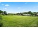 Lush green backyard is enclosed by classic fencing with a large lawn and manicured flower beds at 3340 Emerald Pointe Ct, Monroe, NC 28110