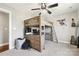 Bedroom with a loft bed featuring a built-in desk, ladder access, and neutral decor at 3340 Emerald Pointe Ct, Monroe, NC 28110
