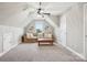 Finished bonus room with sloped ceilings, carpet, comfortable seating, and lots of natural light at 3340 Emerald Pointe Ct, Monroe, NC 28110
