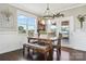 Bright dining area features wood table with bench seating, modern chandelier, and access to outdoor living space at 3340 Emerald Pointe Ct, Monroe, NC 28110
