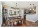Open-concept dining area with wood floors, bench seating, modern lighting, and adjacent kitchen area at 3340 Emerald Pointe Ct, Monroe, NC 28110
