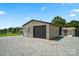 Exterior shot of a brick garage with gravel driveway and backyard fencing at 3340 Emerald Pointe Ct, Monroe, NC 28110
