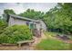 House backyard featuring a green door entrance, stone patio, and wood bench at 40 Old Rd, Taylorsville, NC 28681