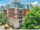 Luxury brick condominium building featuring a manicured entrance, multiple balconies, and lush landscaping, unit #201 at 401 N Church St # 201, Charlotte, NC 28202