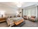 Spacious main bedroom featuring a seating area, carpet, and bay window with plantation shutters at 401 N Church St # 201, Charlotte, NC 28202