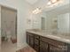 Bathroom with a double vanity, granite countertop, neutral paint, and a view of the toilet and shower at 4305 Twenty Grand Dr, Indian Trail, NC 28079