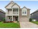 Charming two-story home featuring a covered porch, attached garage, and well-maintained lawn at 4305 Twenty Grand Dr, Indian Trail, NC 28079