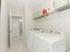 Bright laundry room featuring a washer, dryer, and shelving for ample storage, with a view to the next room at 4305 Twenty Grand Dr, Indian Trail, NC 28079