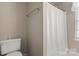Bathroom featuring a toilet, shower with curtain, and natural light for functionality at 4764 Brockton Nw Ct, Concord, NC 28027