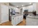 Well-lit kitchen features white cabinets, granite countertops, stainless steel appliances, and hardwood flooring at 4764 Brockton Nw Ct, Concord, NC 28027