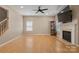 Bright living room featuring hardwood floors, a cozy fireplace, and a ceiling fan at 4764 Brockton Nw Ct, Concord, NC 28027