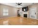 Bright living room featuring hardwood floors, fireplace with a mantle, and a ceiling fan at 4764 Brockton Nw Ct, Concord, NC 28027