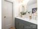 Charming powder room with stylish mirror, double sink vanity, and patterned wallpaper at 4929 Prentice Pl, Charlotte, NC 28210