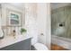 Well-lit bathroom featuring single sink vanity, large mirror, and tiled shower and bathtub at 4929 Prentice Pl, Charlotte, NC 28210