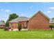 Brick home featuring a backyard patio with a pergola and lush green lawn at 5410 Berryview Ln, Gastonia, NC 28056