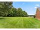 Expansive backyard with lush green grass and mature trees at 5410 Berryview Ln, Gastonia, NC 28056