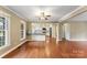 Spacious living area featuring hardwood floors, a ceiling fan, and an adjacent kitchen with bar seating at 5410 Berryview Ln, Gastonia, NC 28056