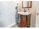Cozy half bathroom featuring a wood vanity, decorative mirror, and tile flooring at 5623 Fetzer Nw Ave, Concord, NC 28027