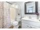 Bright bathroom with a floral shower curtain, white vanity, and modern lighting at 5623 Fetzer Nw Ave, Concord, NC 28027