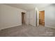 A bright bedroom offers neutral walls, carpeted floors and a double door closet to the left of the room at 7028 Alva Ter, Charlotte, NC 28216