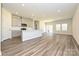 Open-concept kitchen and living area with stainless steel appliances, laminate floors, and white countertops at 7028 Alva Ter, Charlotte, NC 28216