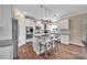 Modern kitchen with stainless steel appliances, granite countertops, a spacious island, and wood flooring at 7046 North Bridge Dr, Huntersville, NC 28078